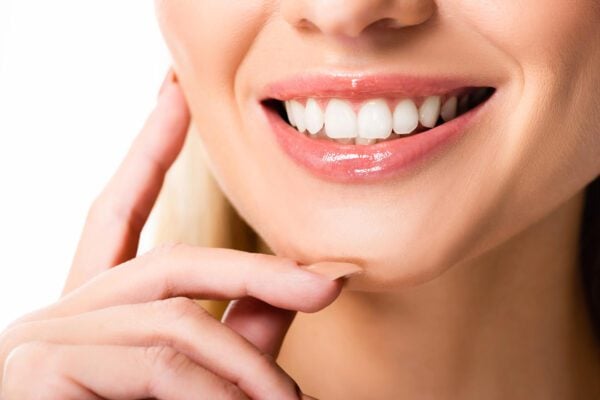 woman proudly showing off her new veneers miami